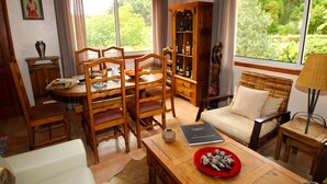 Una sala de estar acogedora con comedor, un sofá y una estantería.