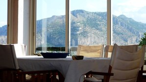 Ein Tisch mit Blick auf eine gebirgige Landschaft durch große Fenster.