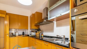 Een moderne keuken met houten kastjes, een roestvrijstalen spoelbak en een ingebouwde oven.