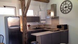 A modern kitchen with a stainless steel refrigerator, a microwave, and a sink. There are two stools and a trash can. - 2 ROOMS + MEZZANINE. All Biarritz on foot.  (Biarritz)