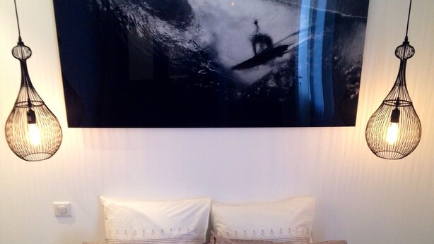 A bedroom with a bed, two hanging light fixtures, and a large abstract painting on the wall. - 2 ROOMS + MEZZANINE. All Biarritz on foot.  (Biarritz)