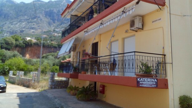 A yellow building with a sign reading "KATERINA APARTMENTS ROOMS INFO". - Katerina Apartments ,( 1 ) One-Bedroom Apartment with Balcony (Kalamata)