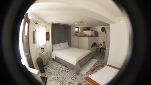 A bedroom with a bed, bedside table, and a small desk area. - "Loft Costera" In the heart of the historic center of Orosei (Orosei, Nuoro)