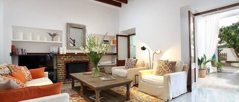A living room with a fireplace, sofas, a coffee table, and a television.
