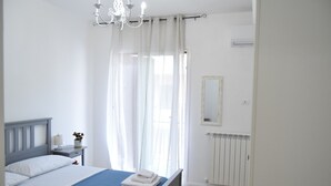 Une chambre à coucher avec un lit, une table de chevet, un miroir et un radiateur.