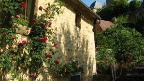 Un bâtiment à la façade en pierre, avec une tour en arrière-plan.