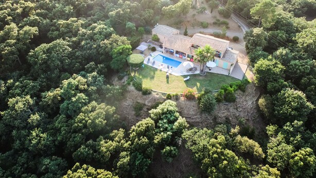 An aerial view of a house surrounded by dense forest, with a swimming pool and outdoor seating area. - Panoramic view Grimaud (La Garde-Freinet)