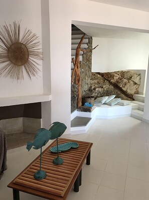 Un interior moderno con una mesa de madera, una escultura decorativa de un pez y una pared de piedra.