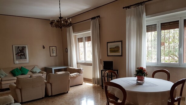 A living room with a sofa, chairs, a dining table, and a TV. - Big house near Appia Antica (Roma)