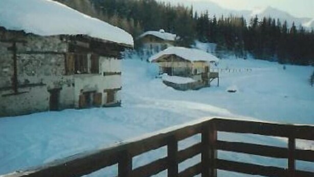 Een dorp bedekt met sneeuw, met pittoreske gebouwen en een houten hek.