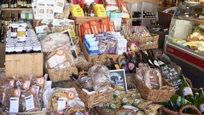 Une vitrine de boulangerie présentant diverses pâtisseries et une pancarte indiquant : « Spécialités pour pique-nique, produits alimentaires et vins ».