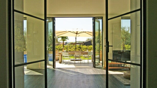 A modern interior with a glass door leading to an outdoor patio area. - The ground floor of a beautifully renovated luxury farm! (Erlecom)