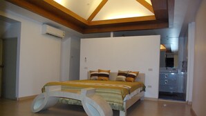 Une chambre à coucher avec un lit, des poutres en bois et un appareil de climatisation.