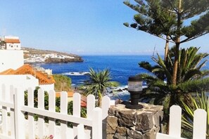 A coastal view with a white fence, a stone wall, and a pine tree. - HOLIDAY HOME "EL MAR" - Nice villa with swimming pool & garden (San Juan de la Rambla)