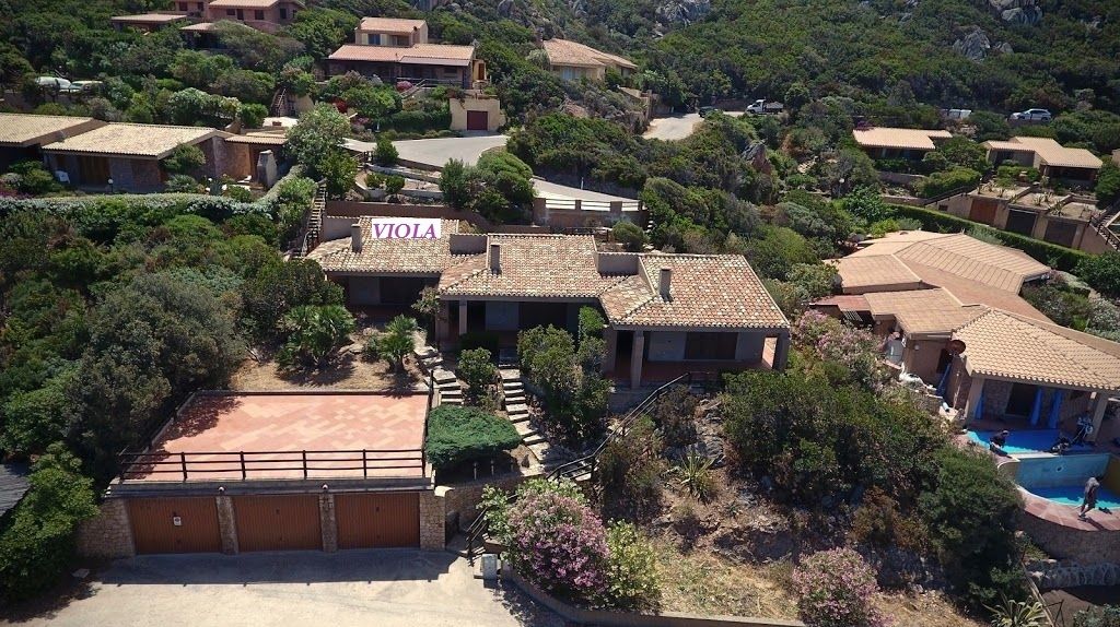 A residential area with multiple houses, a visible driveway, and a swimming pool.