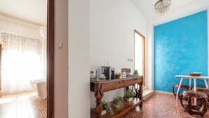Une pièce avec un bureau en bois, un mur d’accent bleu et un sol carrelé.