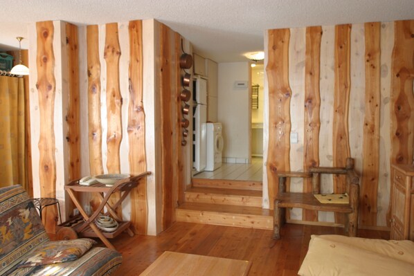 Un interior de madera con un sofá, una silla y una mesita.