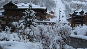 A snow-covered mountain village with traditional wooden buildings, a ski lift, and a clear view of the surrounding snowy landscape. - Very comfortable apartment in the center of the resort- at the foot of the slop (Valloire)