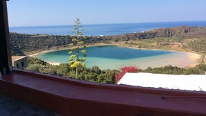 A coastal view from a balcony with a clear view of a turquoise bay, a sandy beach, and the sea. - RESIDENCE VENUS DREAM (Pantelleria)