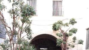 Un callejón empedrado con un arco de piedra que da a un edificio.