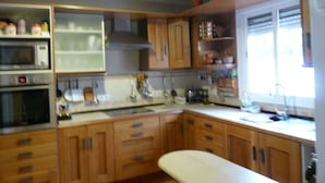 Une cuisine avec des meubles en bois, un four à micro-ondes, un four traditionnel et une fenêtre donnant sur un beau paysage.