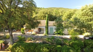 A rustic building with a tiled roof, surrounded by lush greenery and a stone wall. - house - 4 rooms - 4/6 persons (Conqueyrac)