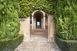 A stone pathway leading to an arched entrance with a view beyond.