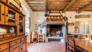 A rustic kitchen with a stone fireplace, wooden cabinets, and a dining table. - Country House Casale dei Gelsi Entire property including swimming pool for private use (Castiglione in Teverina)