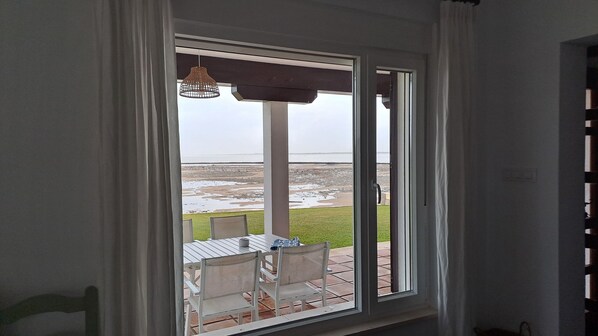 A room with a large sliding glass door leading to an outdoor patio with a table and chairs.