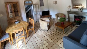 A living room with a sofa, chairs, a table, a cabinet, and a fireplace. - Character house surrounded by vineyards 6 pers (Bollène)