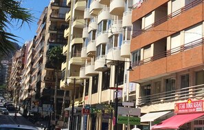 Stunning multi-story building with a mix of architectural styles, featuring balconies with white and red railings.