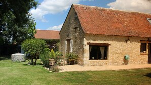 A stone building with a tiled roof, a window, and a door. - "Les Mirabelles"  in deep rural France - (Gardonne)