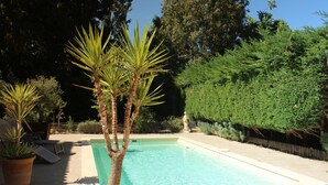 A rectangular swimming pool with a tiled deck, surrounded by potted plants and a wooden deck. - "Les Mirabelles"  in deep rural France - (Gardonne)
