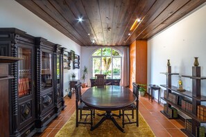 A dining area with a round table, chairs, and a wooden ceiling. - Cottage with pool near the beach (Neiva)