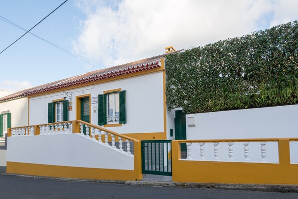 A white building with green shutters and a yellow railing. - HOT WATER HOUSE - RRAL 129 (Ilha de São Miguel, Açores)