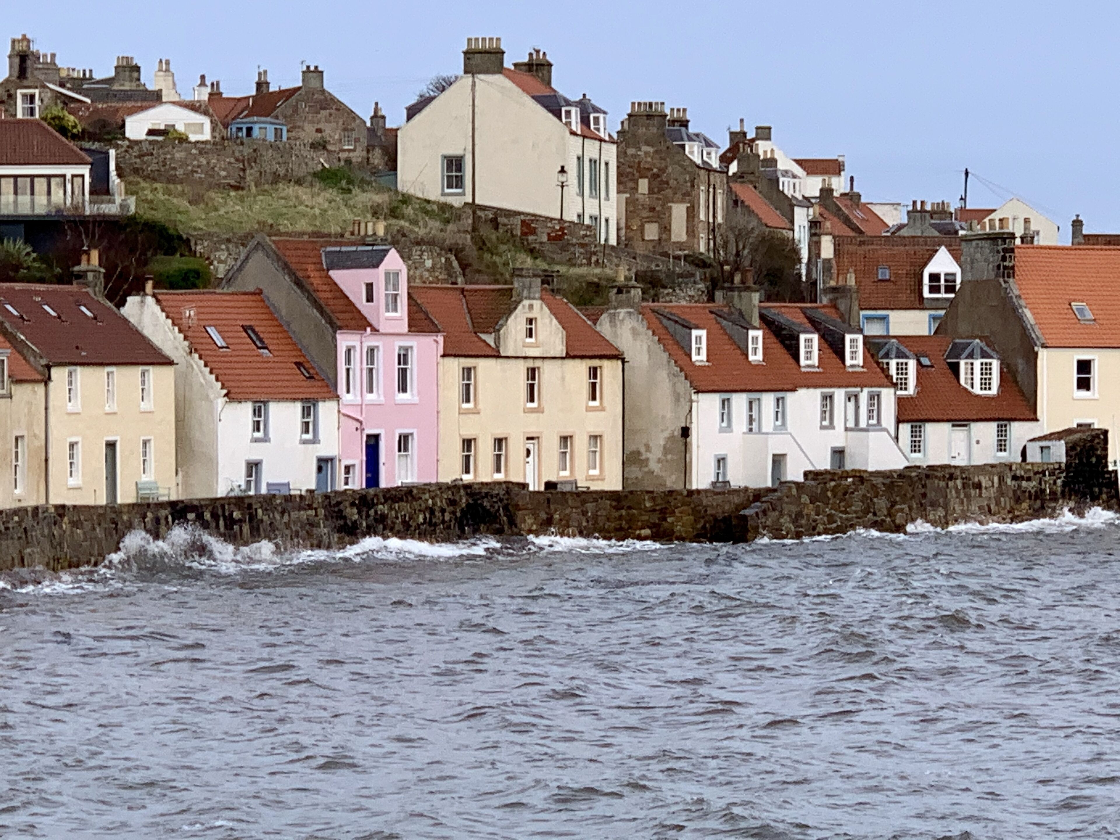 A coastal town with a row of colorful houses along the sea.