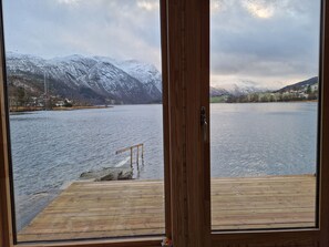 A wooden deck with a view of a lake and snow-covered mountains. - Newly built, high-quality holiday home close to Viksdalsvatnet — sleeps 9 (Viksdalen)