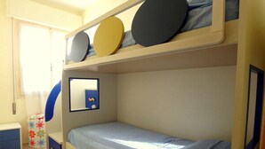 Habitación con literas, un espejo y una mesita de noche pequeña.