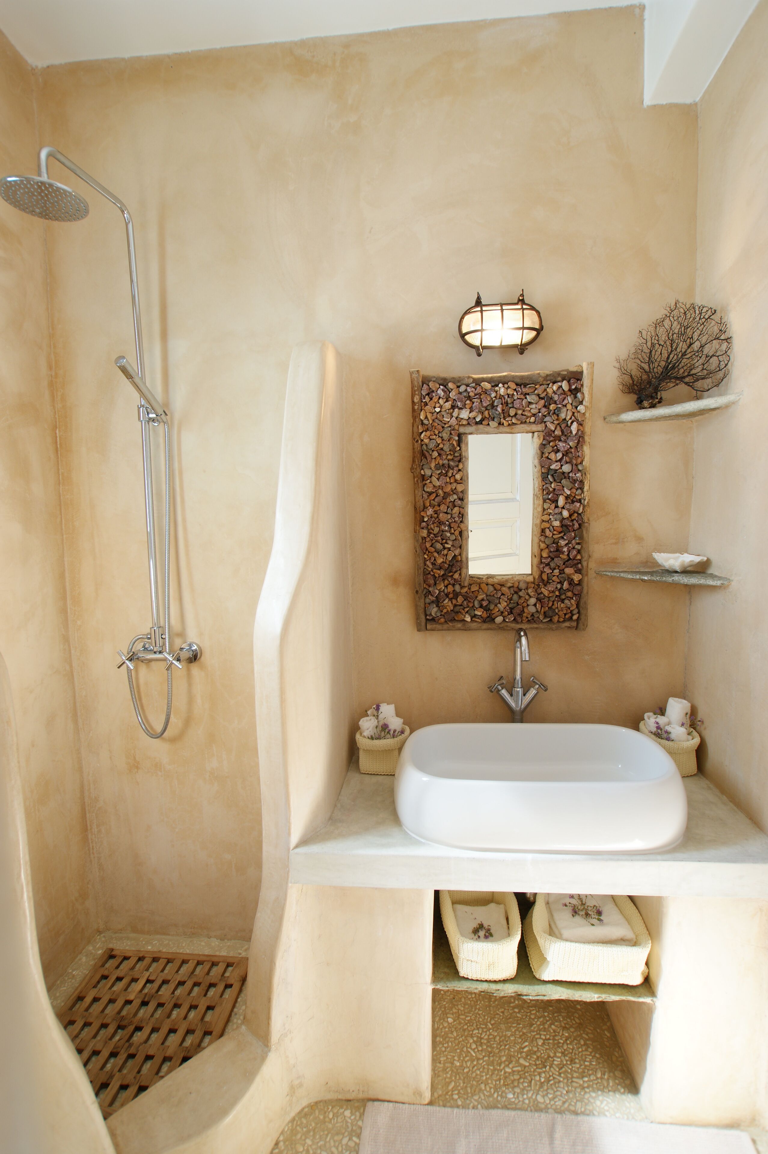 A bathroom with a shower, a sink, and a mirror.