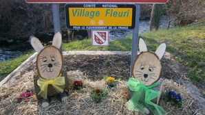 Lautenbach-Zellin kyltin alla on pienempi kyltti, jossa lukee »Village Fleuris», ja kylttiä ympäröivät puiset jänishahmot ja kukat.