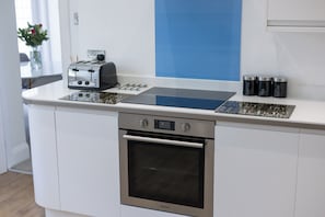 Una cocina con horno integrado, tostadora y cafetera.