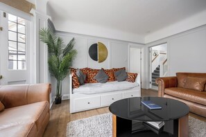 Una sala moderna con un sofá, una mesa de centro y una planta grande.