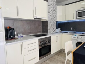 A compact kitchen with a built-in oven, a microwave, and a sink.