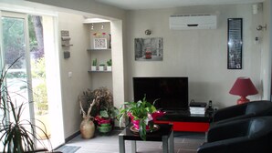 A living room with a TV, a red lamp, and various plants. - The creeks, the sea, the hikes and a beautiful apartment with swimming pool. (Ensuès-La-Redonne)