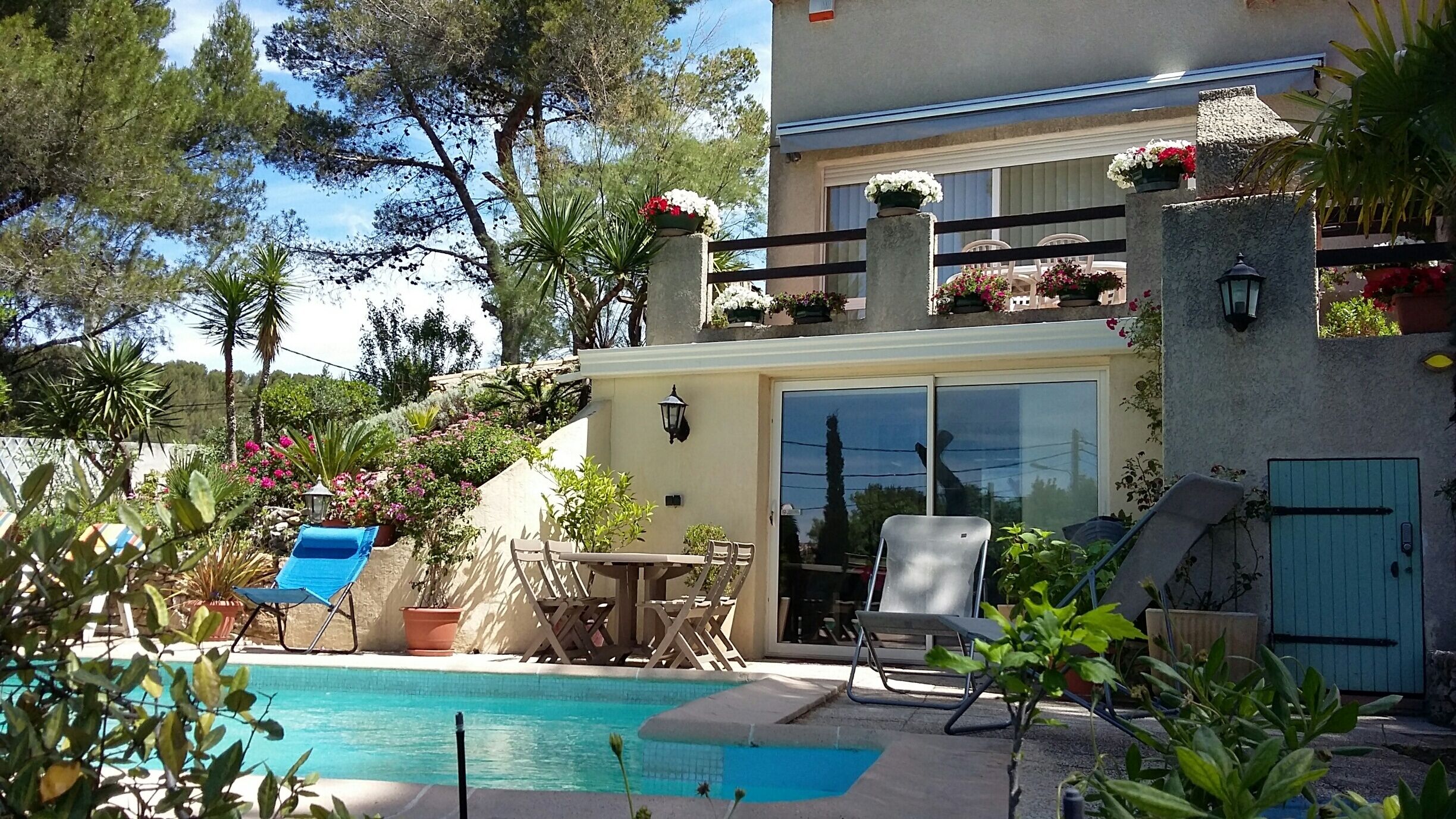 Et poolområde med pool, liggestole og et bord.