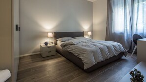 A modern bedroom with a bed, bedside tables, and a desk. -  Civico 88 Modern design (Padova)