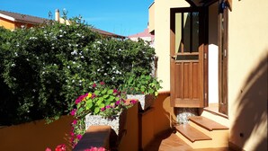 Un bâtiment doté d’une porte en bois et d’un escalier menant à une entrée carrelée.