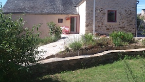 A stone house with a sloped roof, a small window, and a door. - The Lily Féliz, a pretty village house between Rodez and Albi (Centrès)