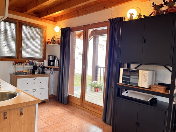 A kitchen with a sink, cabinets, a coffee machine, and a microwave.