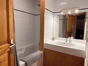 Combined shower/bathtub, hair dryer, slippers, towels